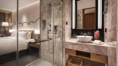 a bathroom with a shower and a bed and a sink at Holiday Inn Nanjing Qinhuai South by IHG in Jiangning