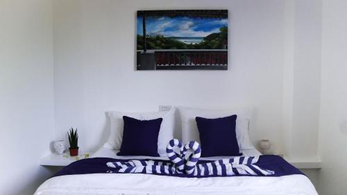 a bedroom with a bed with blue and white pillows at Tablas Seaview Homestay in Ferrol