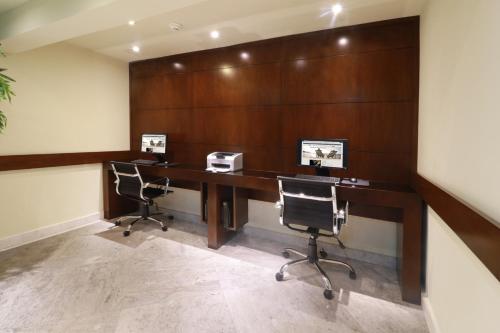 an office with a desk with two computers and two chairs at Holiday Inn Monterrey Norte by IHG in Monterrey