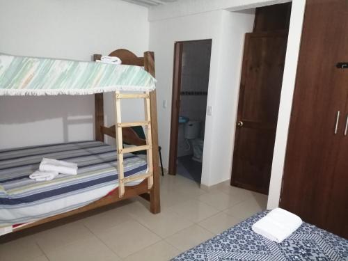 a bedroom with two bunk beds and a bathroom at Casa Campestre La Quinfalia in Luna Park