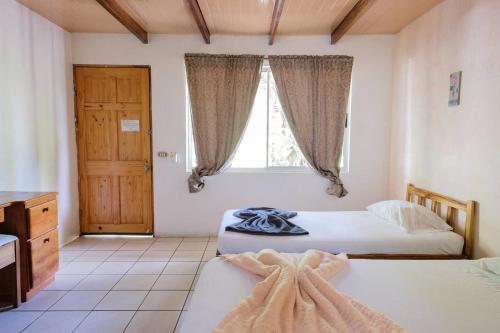 - une chambre avec 2 lits et une fenêtre dans l'établissement Mapi's Cabins, à Paquera
