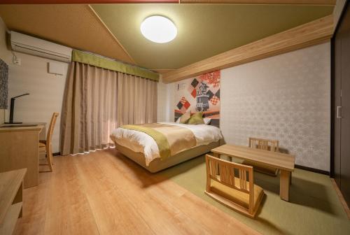 a bedroom with a bed and a table in it at Residence Hotel Takayama Station in Takayama