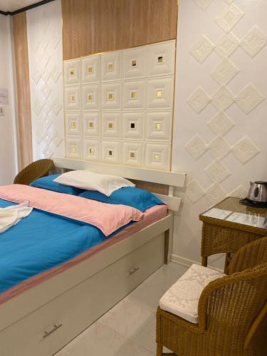 a bedroom with a bed and a table and a chair at Monallan Boracay Hotel in Boracay