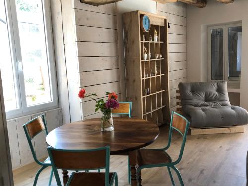 a dining room with a table and chairs and a couch at NID DOUILLET in Sancerre