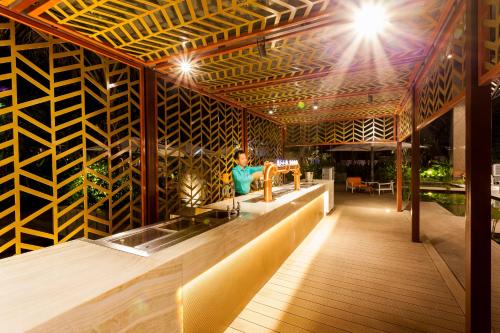a woman standing at a bar in a restaurant at Crowne Plaza Vientiane by IHG in Vientiane