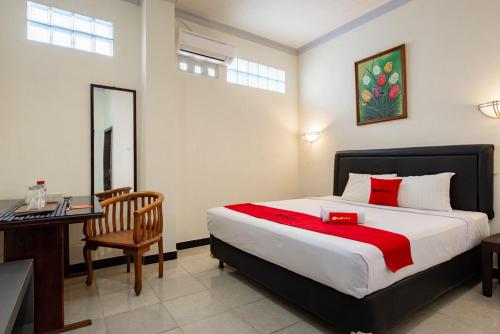 um quarto com uma cama e uma secretária e uma cama e uma secretária em RedDoorz Plus near Balai Kota Batu 2 em Malang