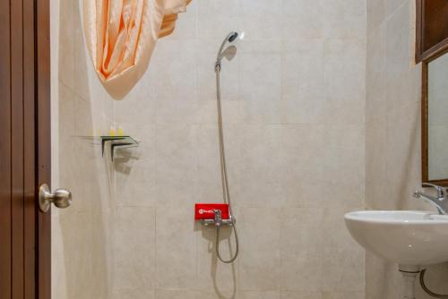 una ducha en un baño con inodoro y lavabo en RedDoorz Plus near Balai Kota Batu 2, en Malang