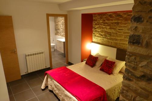 um quarto com uma cama com um cobertor vermelho em La Solana de Jaca - Casa Collarada em Novés