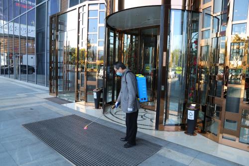 a man is standing outside of a building with a dog at Yiwu Shangcheng Hotel in Yiwu