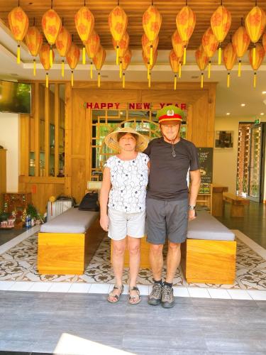 a man and a woman standing in front of a store at MaiChi Villa Hoi An in Hoi An