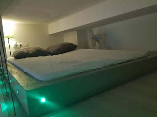 a bed in a room with a green light at Studio au Coeur de Marseille in Marseille