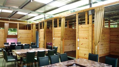 尖石鄉的住宿－水田私房農園，用餐室设有木墙和桌椅