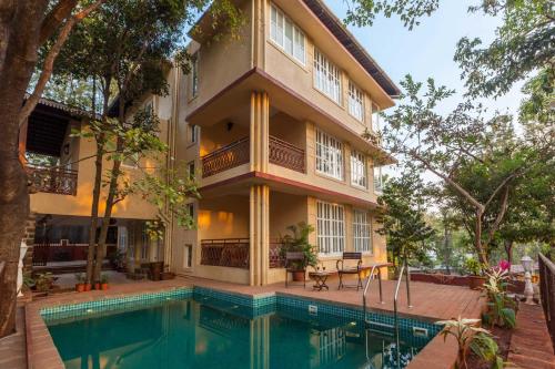 a house with a swimming pool in front of a building at Antilia Villa - Luxurious-AC-Swimming pool in Panchgani