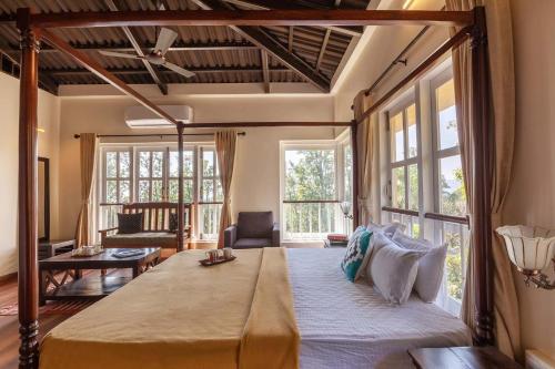 a bedroom with a large bed in a room with windows at Antilia Villa - Luxurious-AC-Swimming pool in Panchgani