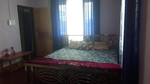 a bedroom with a bed with a window and a window at Pandeys Homestay Kalimpong in Kalimpong