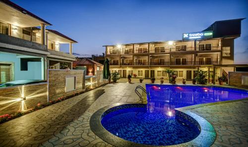 a hotel with a swimming pool in front of a building at Treebo JP Cottage in Mahabaleshwar