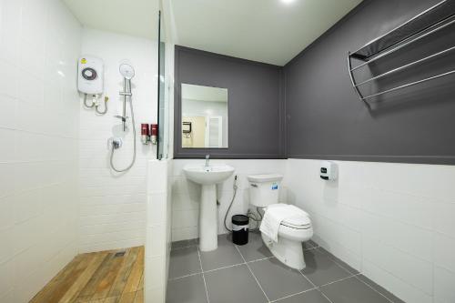 a bathroom with a toilet and a sink at โรงแรมต้นเงิน in Khon Kaen