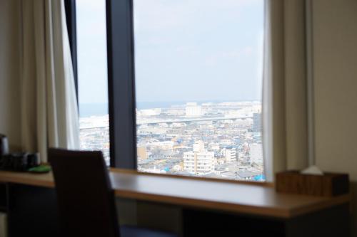 a view of a city from a window in a room at Izumisano Center Hotel Kansai International Airport in Izumi-Sano