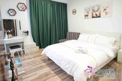 a bedroom with a white bed and a green curtain at Floral Elegance1 @ Galacity in Kuching