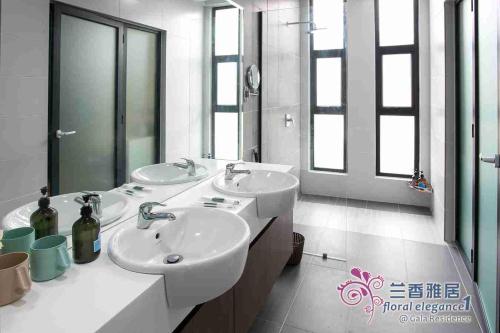 a bathroom with two sinks and two mirrors at Floral Elegance1 @ Galacity in Kuching