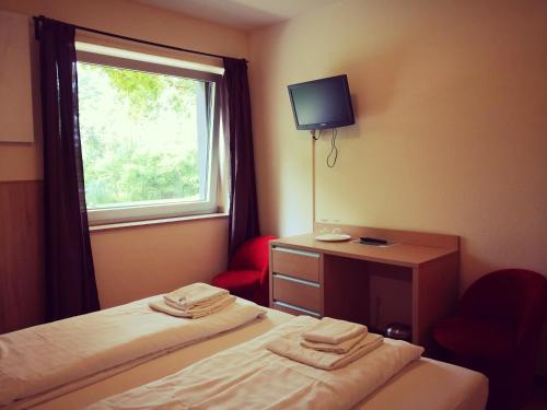 a hotel room with two beds and a window at Hotel Mettmann in Mettmann