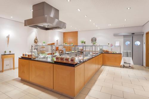un restaurant avec un comptoir où vous pourrez manger dans l'établissement Holiday Inn Nürnberg City Centre, an IHG Hotel, à Nuremberg