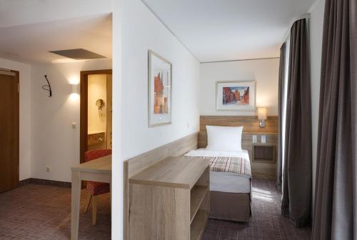 two pictures of a hotel room with a bed at Holiday Inn Nürnberg City Centre by IHG in Nürnberg