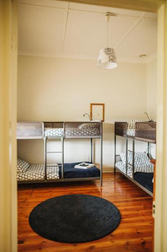 two bunk beds in a room with a rug at Cooke Cottage in Clare