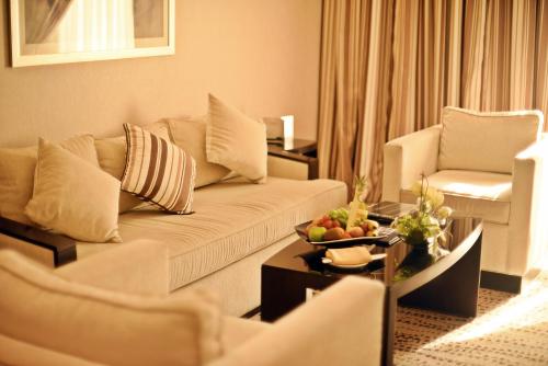 a living room with a couch and a table at Golden Tulip Bahrain in Manama
