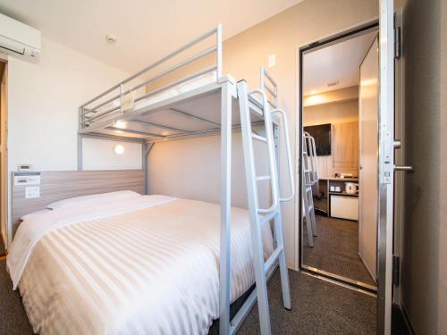 1 dormitorio con litera y escalera en Super Hotel Premier Musashi Kosugi Ekimae, en Kawasaki