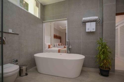 a bathroom with a white tub and a toilet at Kandy Hills in Kandy