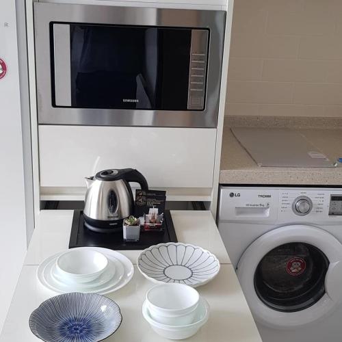 a kitchen with a microwave and a washing machine at The Mark Sokcho Residence #16 Level in Sokcho