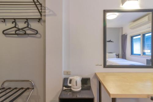 - un miroir dans une chambre avec un lavabo et un lit dans l'établissement Intown Residence, à Bangkok