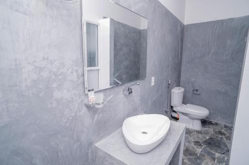 a bathroom with a toilet and a sink and a mirror at Pineview in Unawatuna