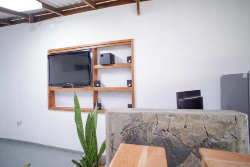 a living room with a tv on a wall at Pineview in Unawatuna