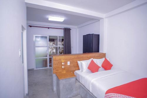 a bedroom with a bed with red pillows at Pineview in Unawatuna