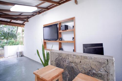 a living room with a tv on a wall at Pineview in Unawatuna