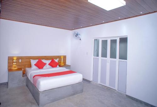 a bedroom with a bed with red pillows at Pineview in Unawatuna
