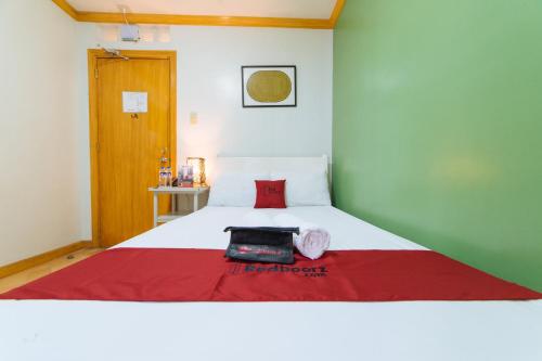 a bedroom with a bed with a red blanket on it at RedDoorz @ Arimbay Legazpi City in Legazpi