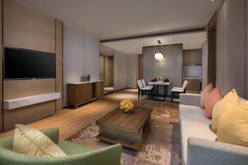 a living room with a couch and a table with chairs at Holiday Inn Nanjing Harbour by IHG in Nanjing