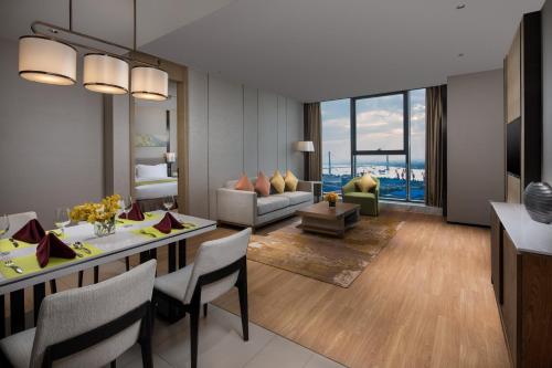 a living room with a dining table and a couch at Holiday Inn Nanjing Harbour by IHG in Nanjing
