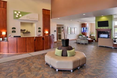 a lobby with a waiting area with a couch and a chair at Holiday Inn Madison at The American Center by IHG in Madison