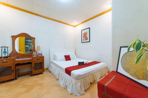 a bedroom with a bed and a dresser and a mirror at RedDoorz @ Arimbay Legazpi City in Legazpi