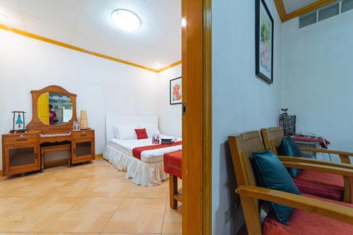 a bedroom with a bed and a dresser and a mirror at RedDoorz @ Arimbay Legazpi City in Legazpi