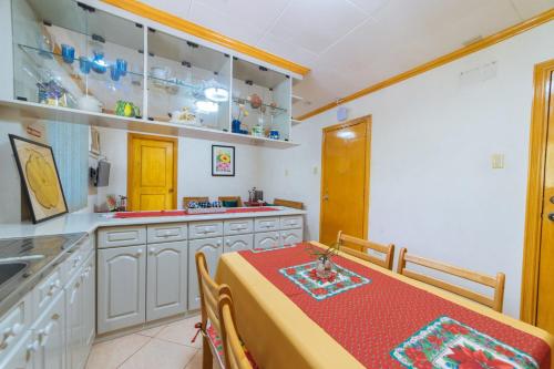 a kitchen with a table with a red table cloth at RedDoorz @ Arimbay Legazpi City in Legazpi