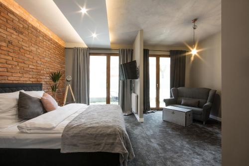 a bedroom with a bed and a brick wall at Rakowicka Top Apartaments Superior in Krakow