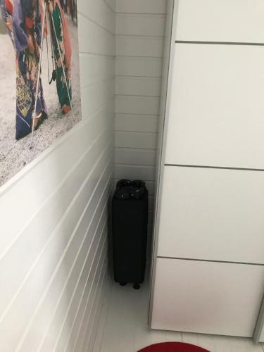 a suitcase in a room with white walls at Waterfront Twin Cabin in Stamsund