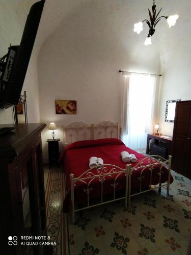a bedroom with a red bed and a window at Agli Antichi Quartieri Apartments & Room in Alcamo