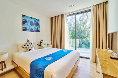 a bedroom with a large bed and a large window at Clean & Quiet Villa - The Point Resort in Da Nang