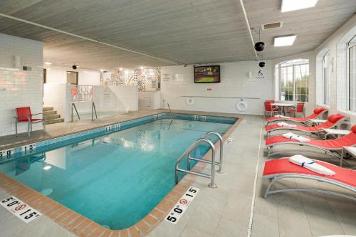 a large swimming pool with red chairs around it at Holiday Inn - Bloomington W MSP Airport Area by IHG in Bloomington